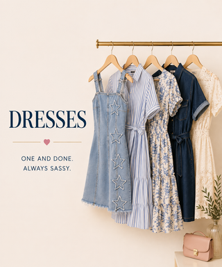 Four women's dresses in different styles and colors hang on a gold clothing rack against a warm cream background. The dresses include a light blue denim dress with white star embroidery, a blue and white striped dress, a blue and white floral dress, and a dark navy blue denim dress.